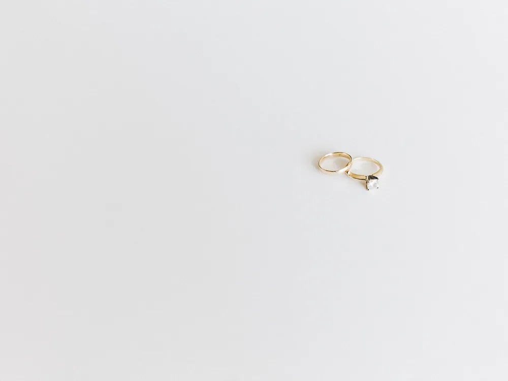 A pair of plain gold wedding rings resting on a clean white surface
